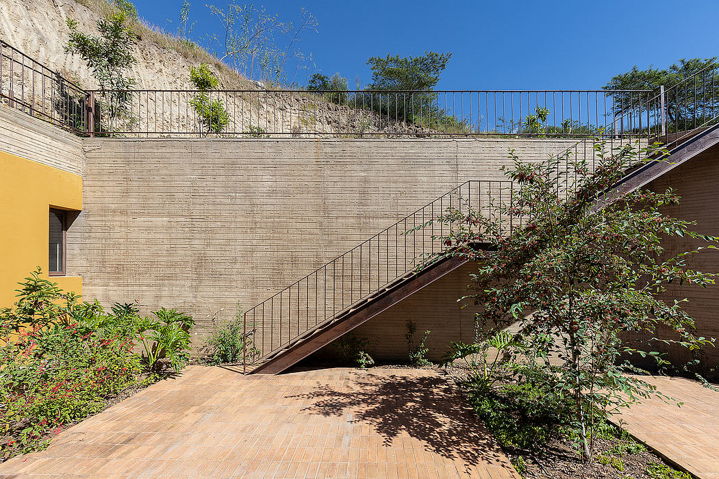 Concrete outdoor staircase with metal railing, surrounded by lush vegetation.