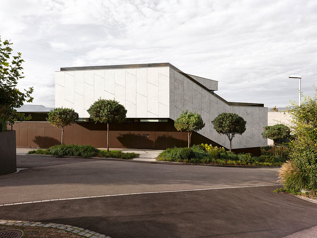 A modern, rectangular building with a sleek, minimalist facade and surrounding landscaping.