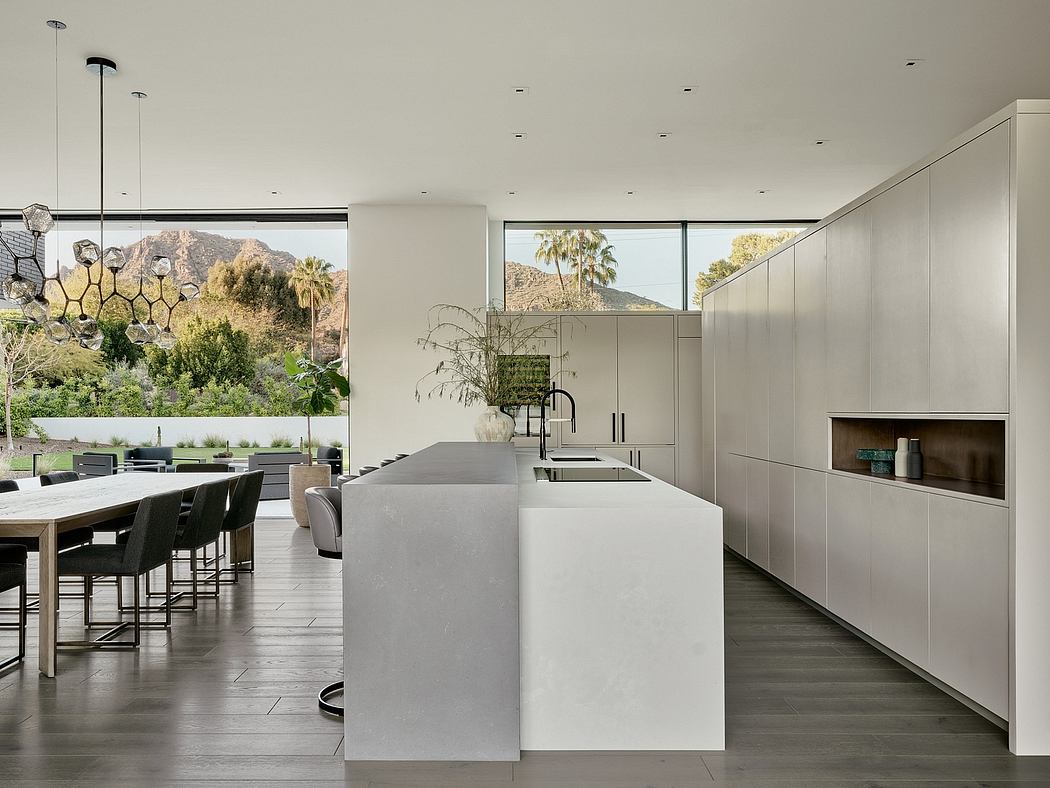 Sleek, minimalist kitchen with large windows showcasing stunning mountain views.