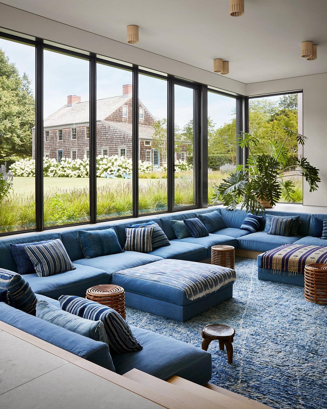Spacious living room with large windows overlooking a lush outdoor landscape.