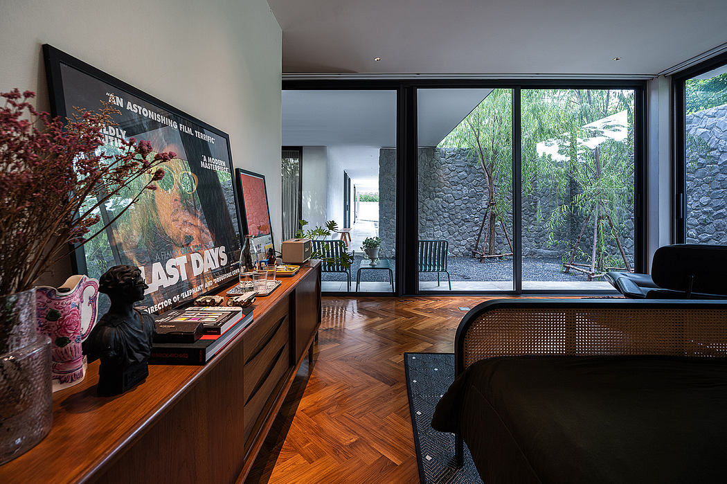 Cozy modern home interior with hardwood floors, stone walls, and large windows overlooking nature.