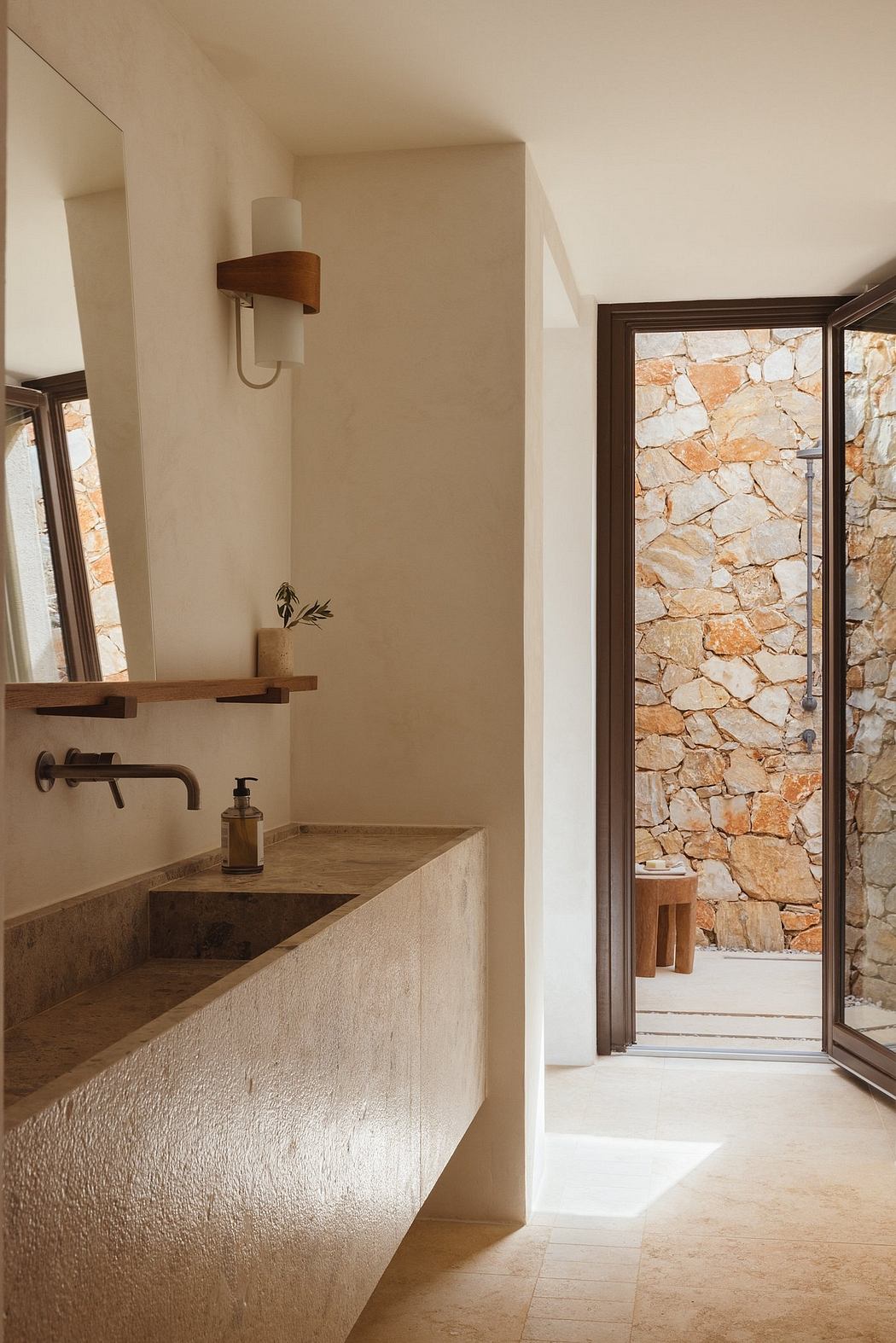 Modern bathroom with stone wall, wooden accents, and minimalist design.