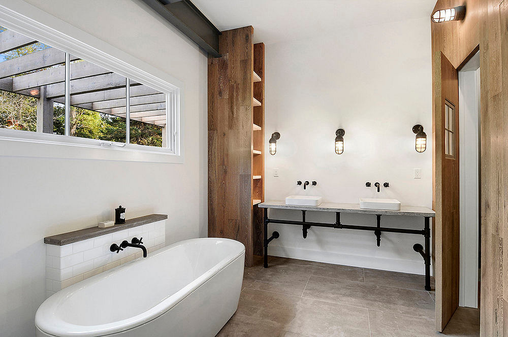 Sleek, modern bathroom with freestanding tub, dual vanity, and rustic wood accents.