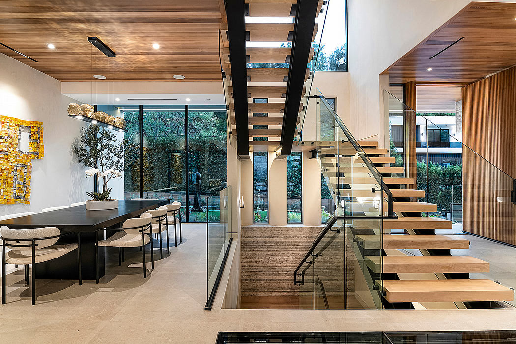 A modern, open-concept living space with a sleek staircase, glass walls, and natural wood accents.