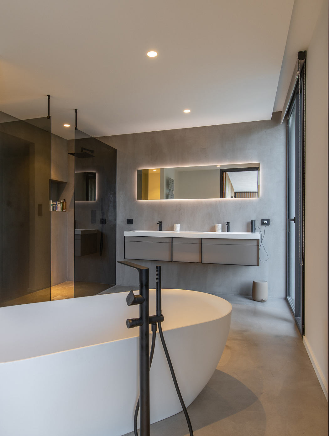 Sleek, modern bathroom with freestanding tub, double vanity, and recessed lighting.