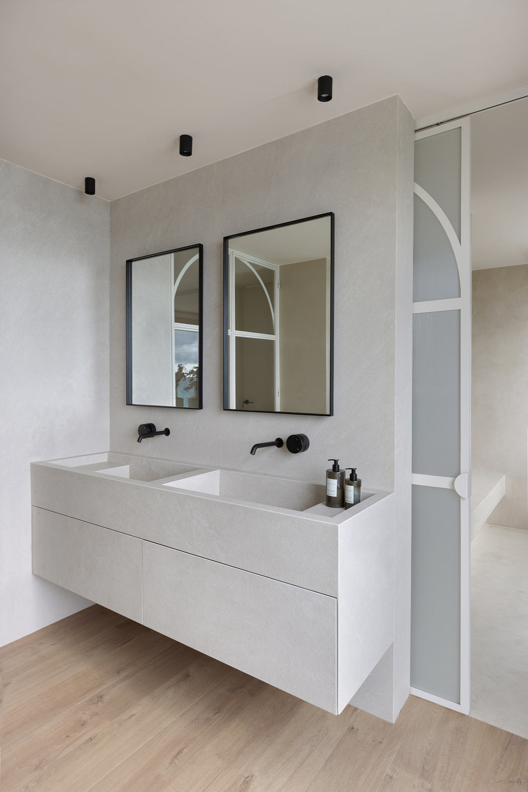 Modern, minimalist bathroom vanity with dual sinks, black fixtures, and framed mirrors.