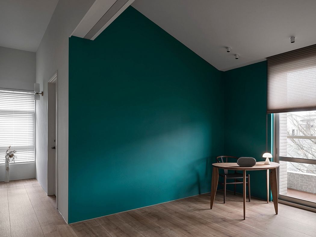 A modern room with a dramatic teal accent wall, minimal furniture, and sleek lighting.