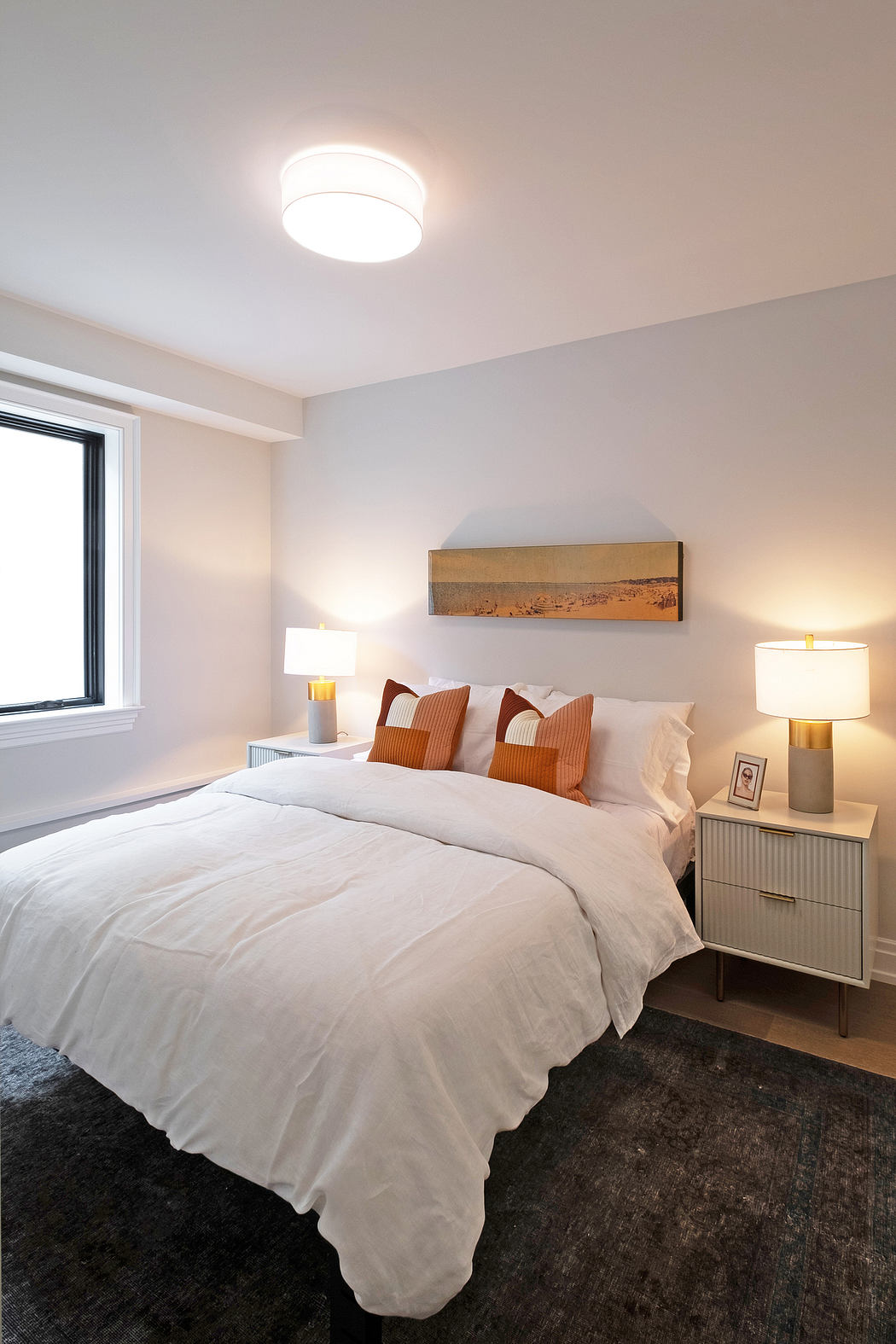 Cozy bedroom with warm lighting, textured bedding, and contemporary furnishings.