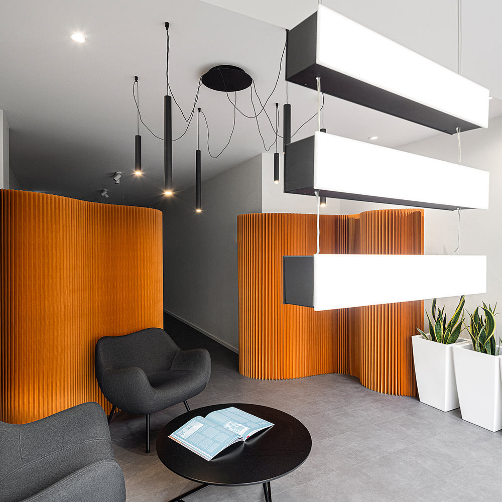 An intriguing modern office space with striking orange timber paneling, sleek furniture, and thoughtful lighting.
