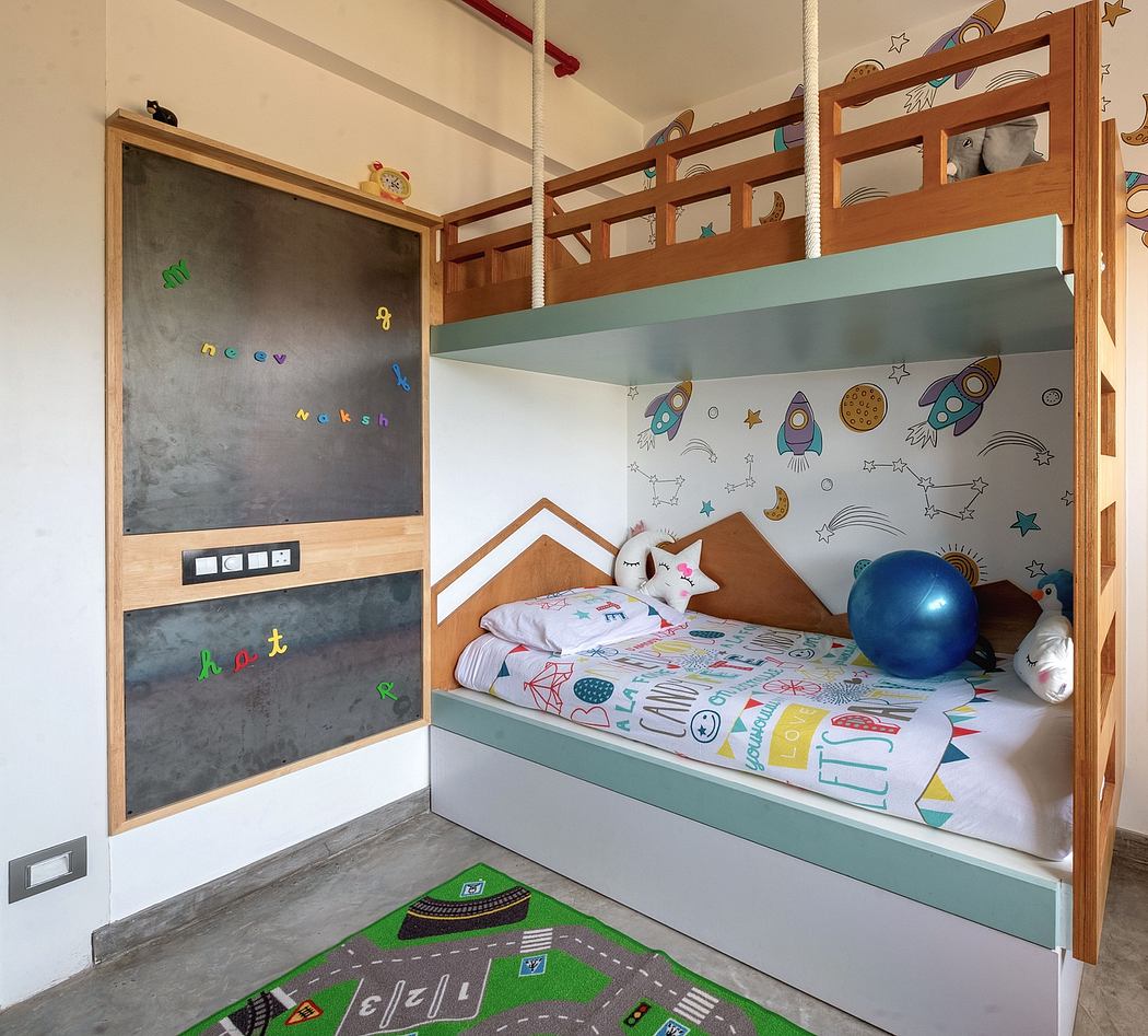 A cozy and colorful children's bedroom with bunk beds, chalkboard, and playful decor.