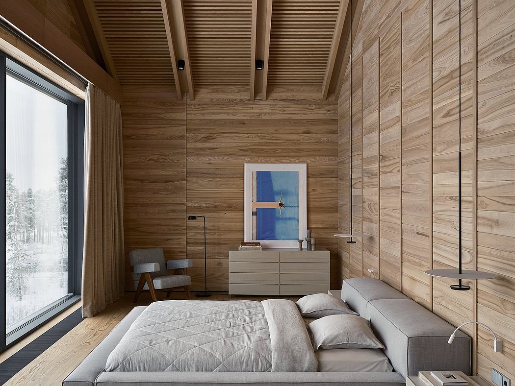 A cozy, wood-paneled bedroom with a large window overlooking a snowy landscape.