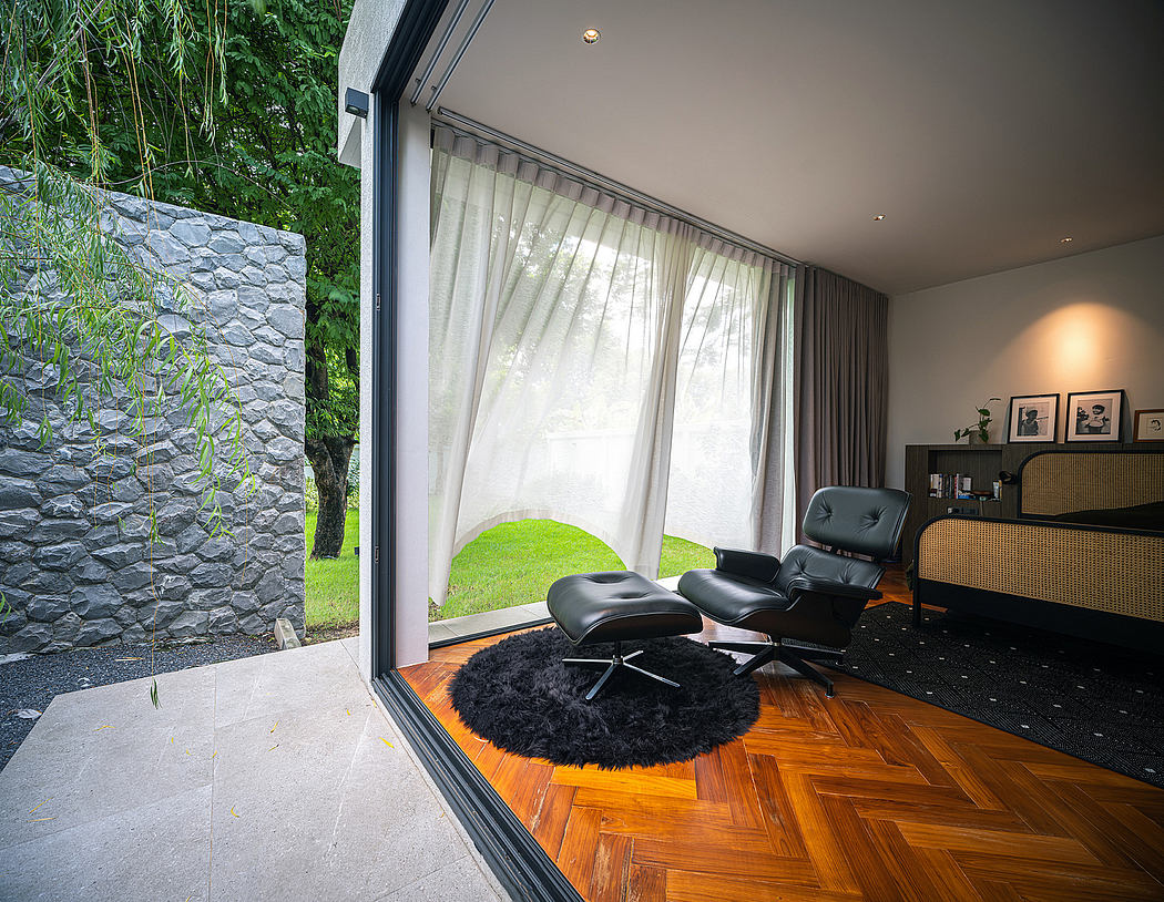 A contemporary living space with floor-to-ceiling windows, hardwood floors, and a plush armchair.