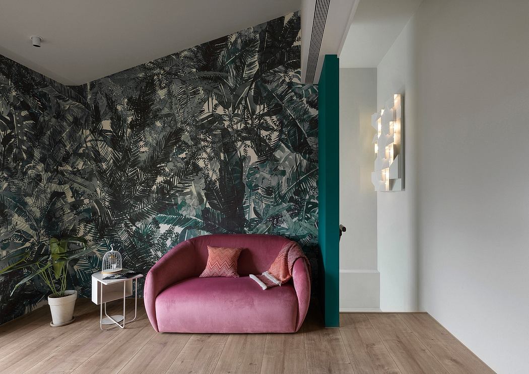 The space features a vibrant tropical-themed wallpaper, a plush pink sofa, and lighting fixtures that add warmth and sophistication to the interior design.