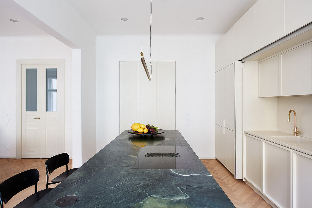 A modern kitchen with a sleek, minimalist design and a large, dark marble countertop.