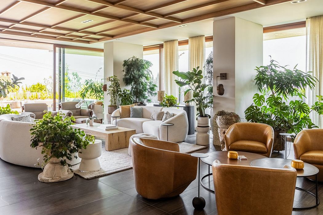 Spacious, light-filled interior with wooden ceiling beams, plush seating, and abundant greenery.