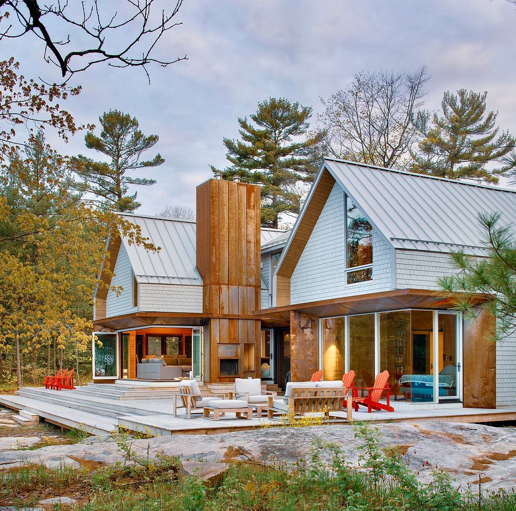 Modern cabin-style home with wood and metal accents, large windows, and expansive deck.