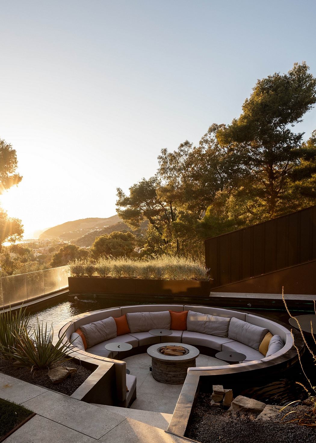 Stunning outdoor lounge area with circular seating, fire pit, and mountain views.