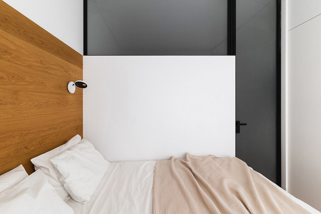 Sleek, minimalist bedroom design with wood paneling, black trim, and white walls.