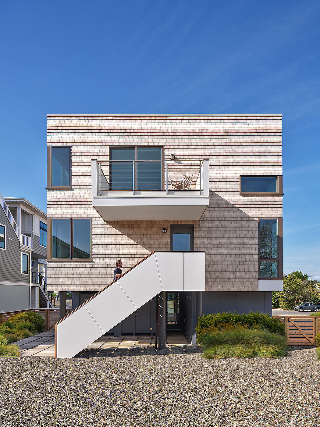 A contemporary residential building with a multilayered facade and an intriguing exterior staircase.