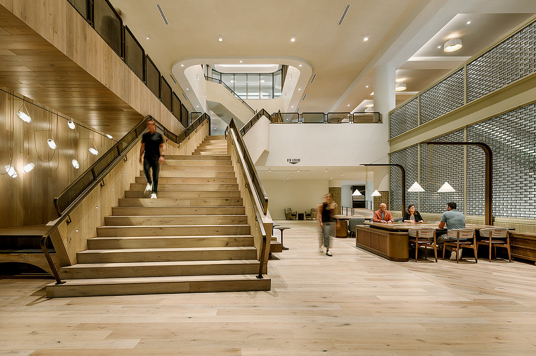 A modern, open-plan interior with wooden stairs, metal accents, and a dining area.