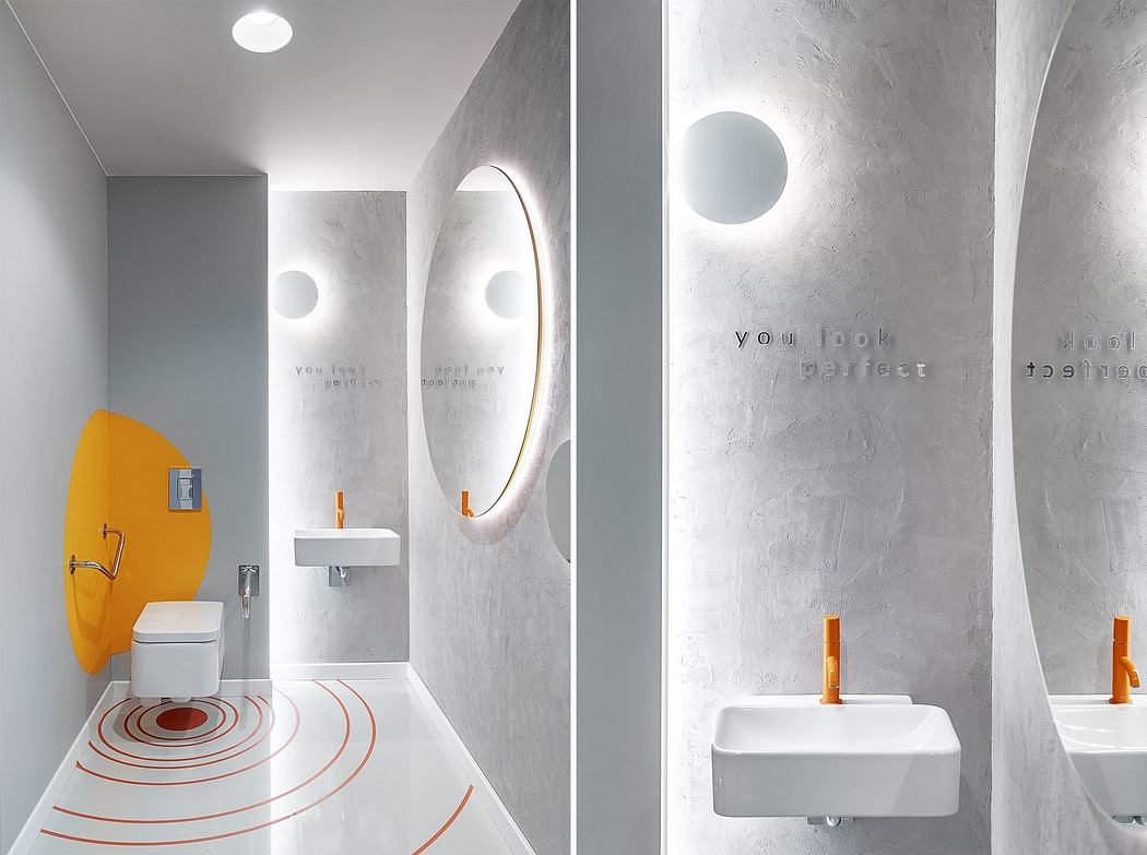 Minimalist bathroom with concrete walls, circular mirrors, and playful orange accents.