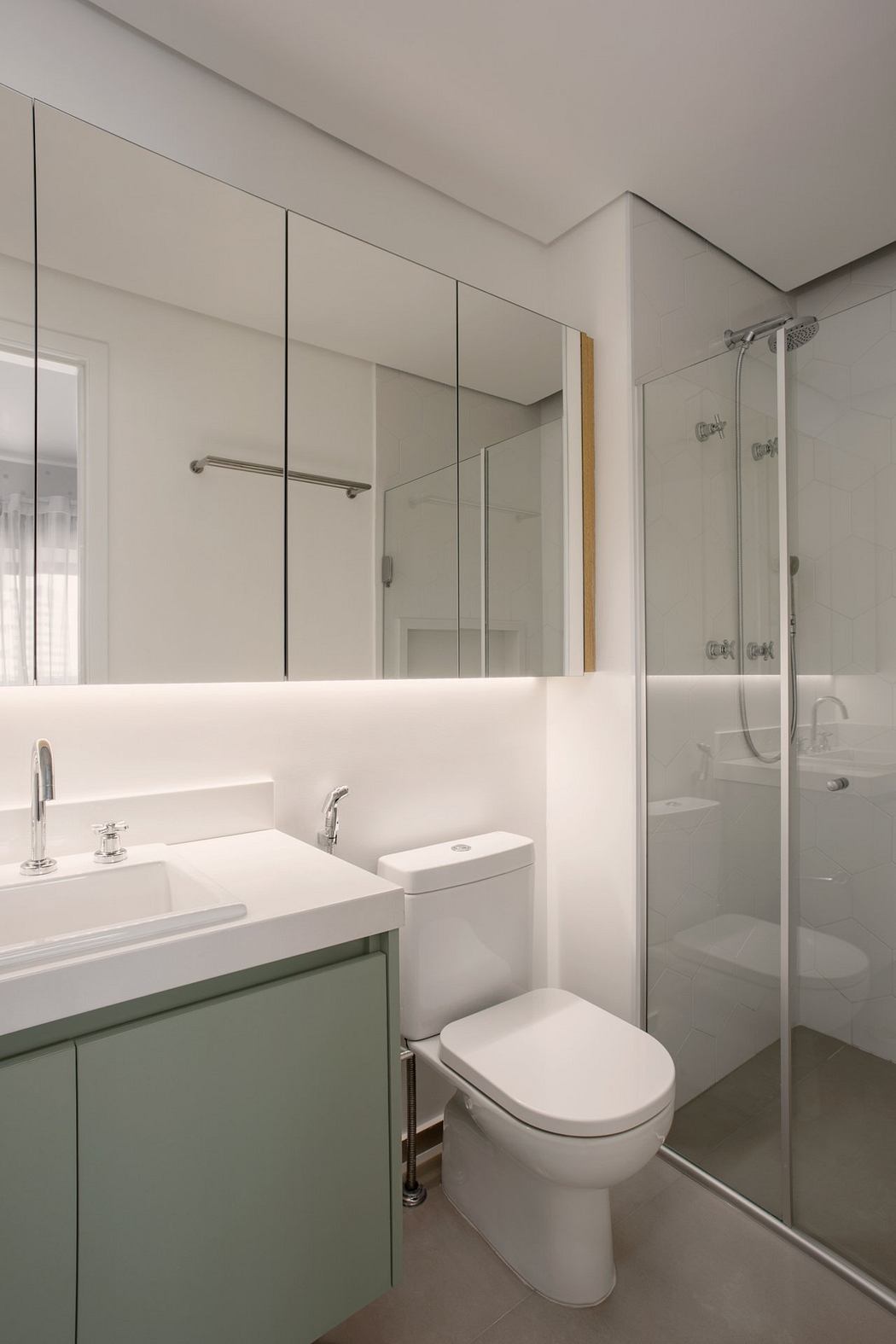 Modern bathroom with minimalist white vanity, glass shower, and recessed lighting.