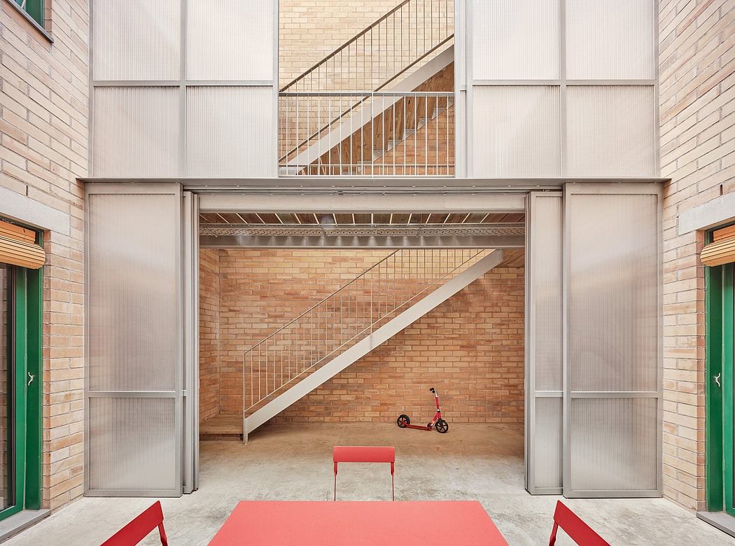 A modern brick building with an open staircase, minimalist furnishings, and a red scooter.