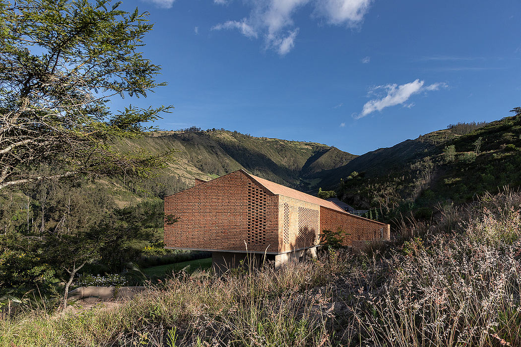 A brick and wooden structure set against a backdrop of rugged mountainous terrain.