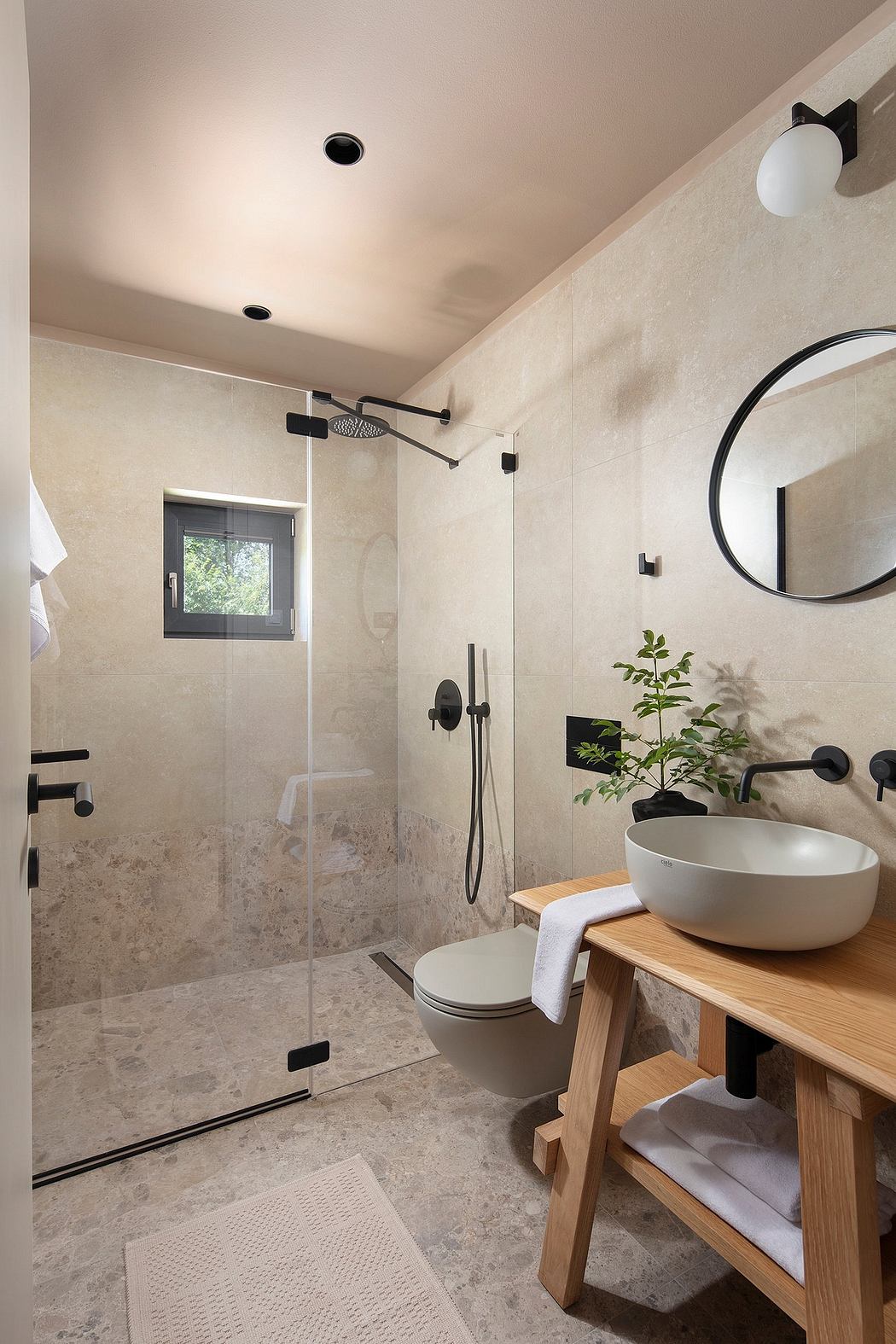 Contemporary bathroom design with sleek black fixtures, a wooden vanity, and a glass shower enclosure.