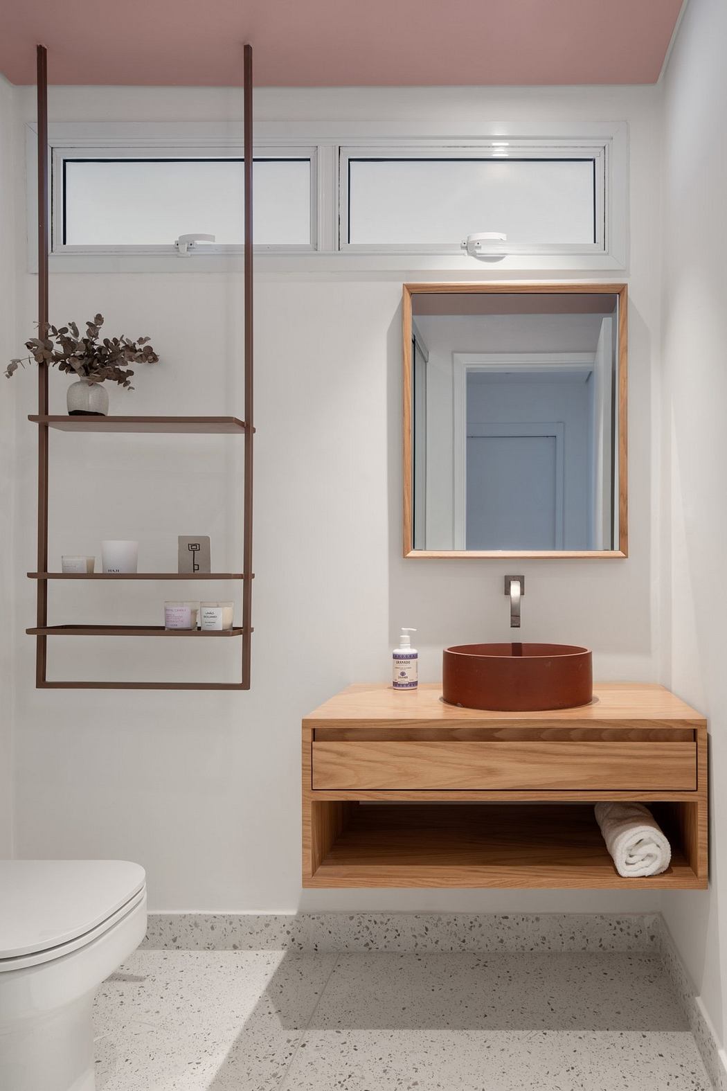 Modern bathroom design with wood furniture, shelving, and copper sink basin.