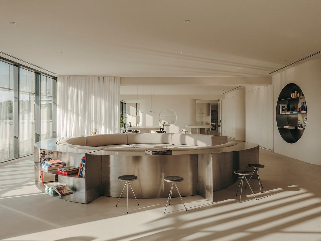 Spacious, modern living room with curved, built-in seating and bar area.