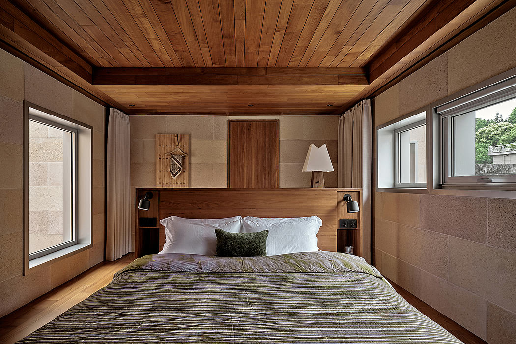 Cozy rustic bedroom with wooden ceiling, built-in headboard, and muted color palette.