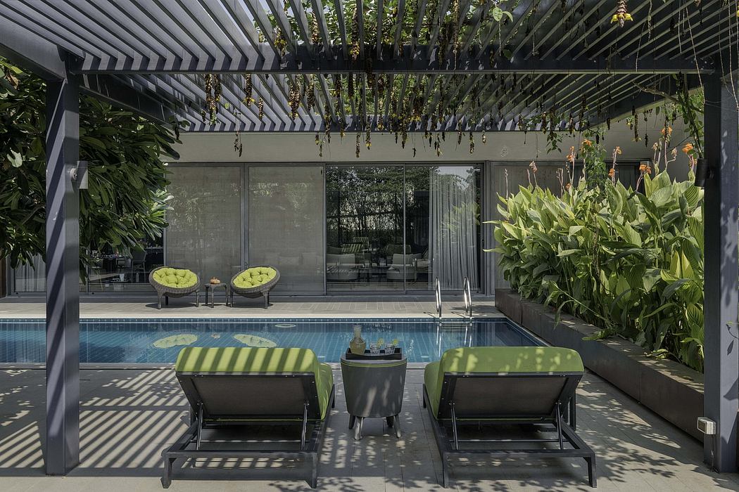 Sleek, modern outdoor retreat with lush greenery, pool, and striped loungers.