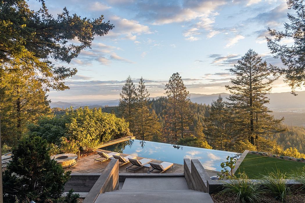 Stunning infinity pool with wooden deck overlooking lush forest landscape.