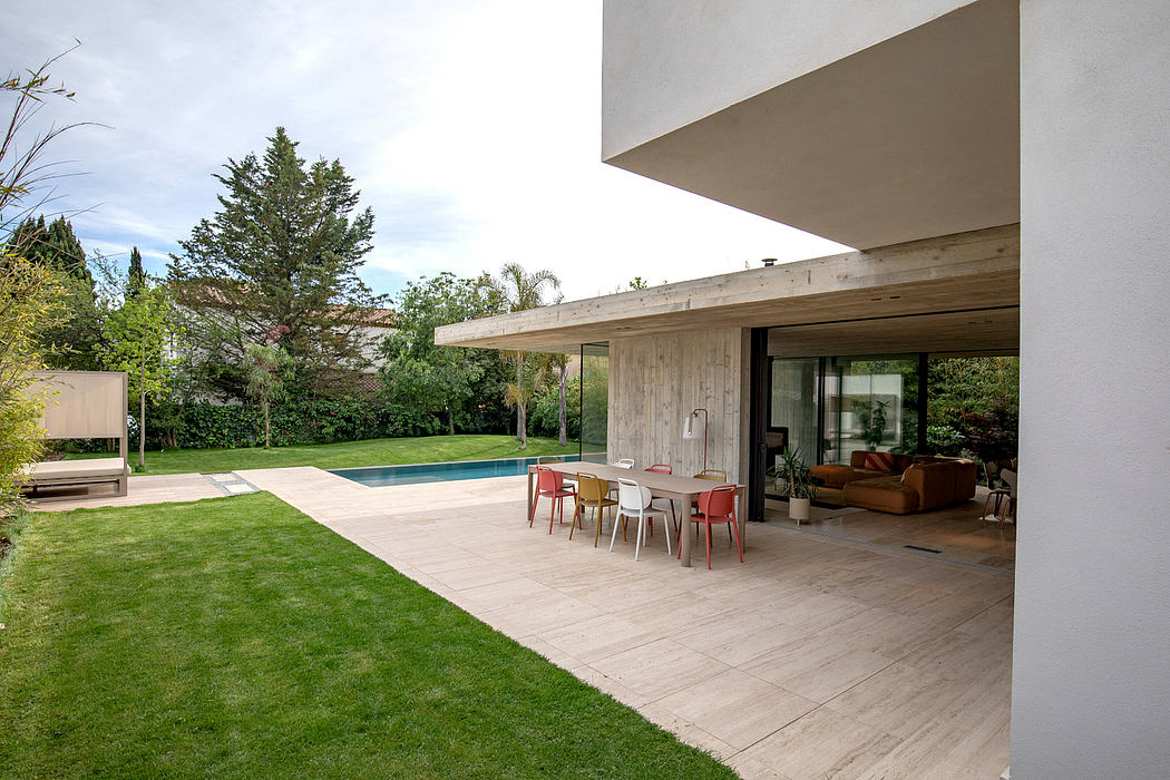 Contemporary home with an inviting outdoor seating area, pool, and lush greenery.