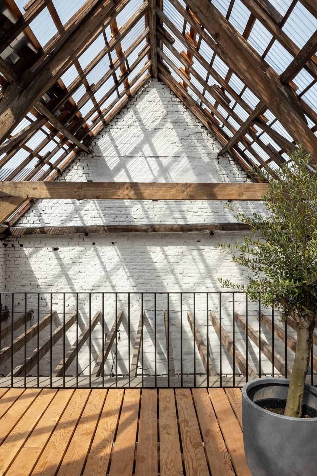 A wooden and brick structure with a peaked roof and modern railing design.