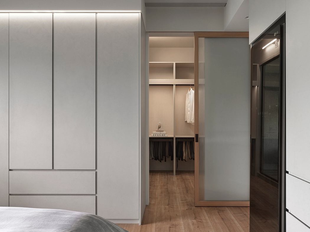 Minimalist bedroom with built-in storage, wooden flooring, and open closet space.