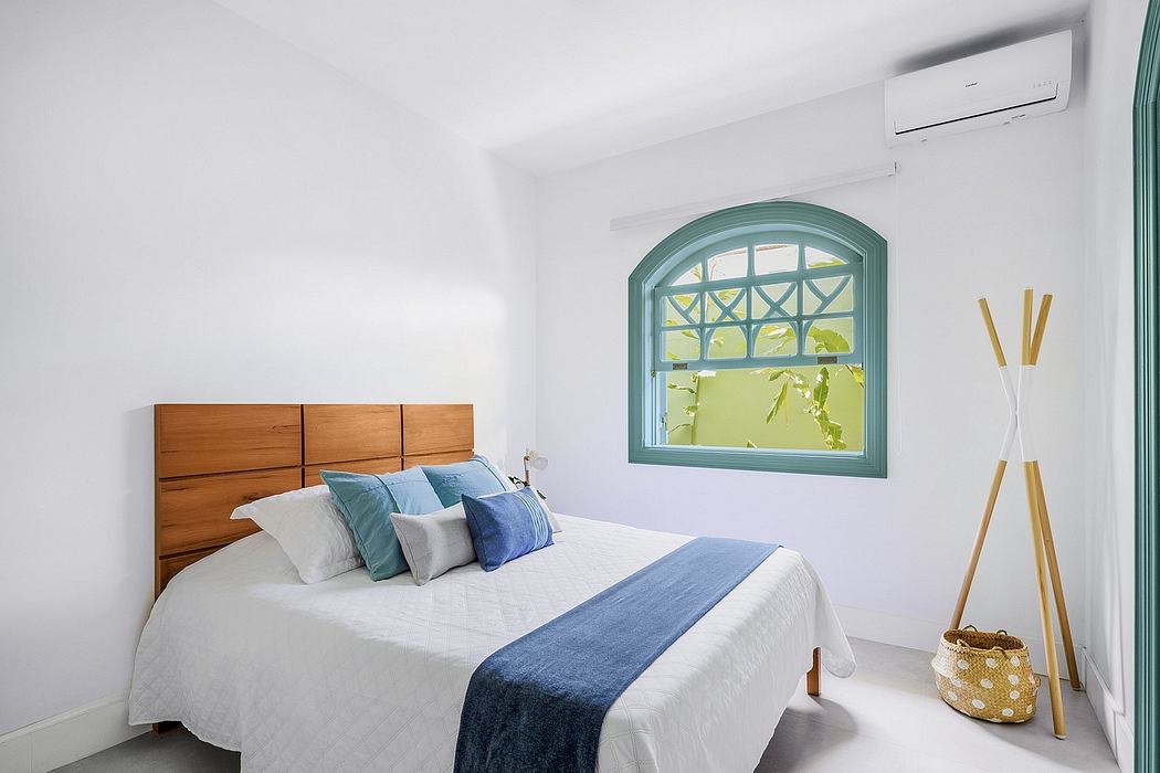 Spacious bedroom with wooden headboard, arched window, and modern amenities.