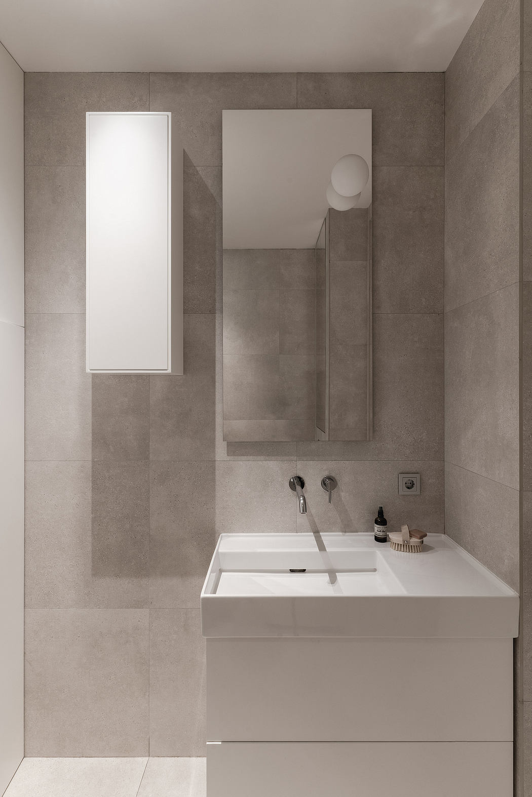 A minimalist bathroom with clean lines, large mirror, and modern sink fixture.