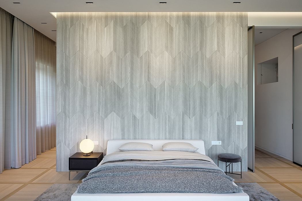Large, modern bedroom with minimalist furniture and a geometric patterned wall.
