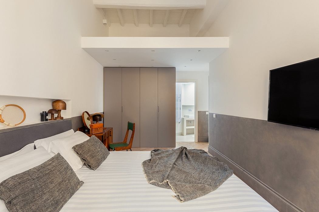 A cozy bedroom with a structured, minimalist design featuring a large wardrobe and sleek furniture.