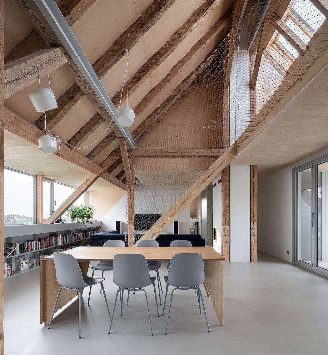 Cozy loft with exposed wooden beams, minimalist furniture, and abundant natural light.