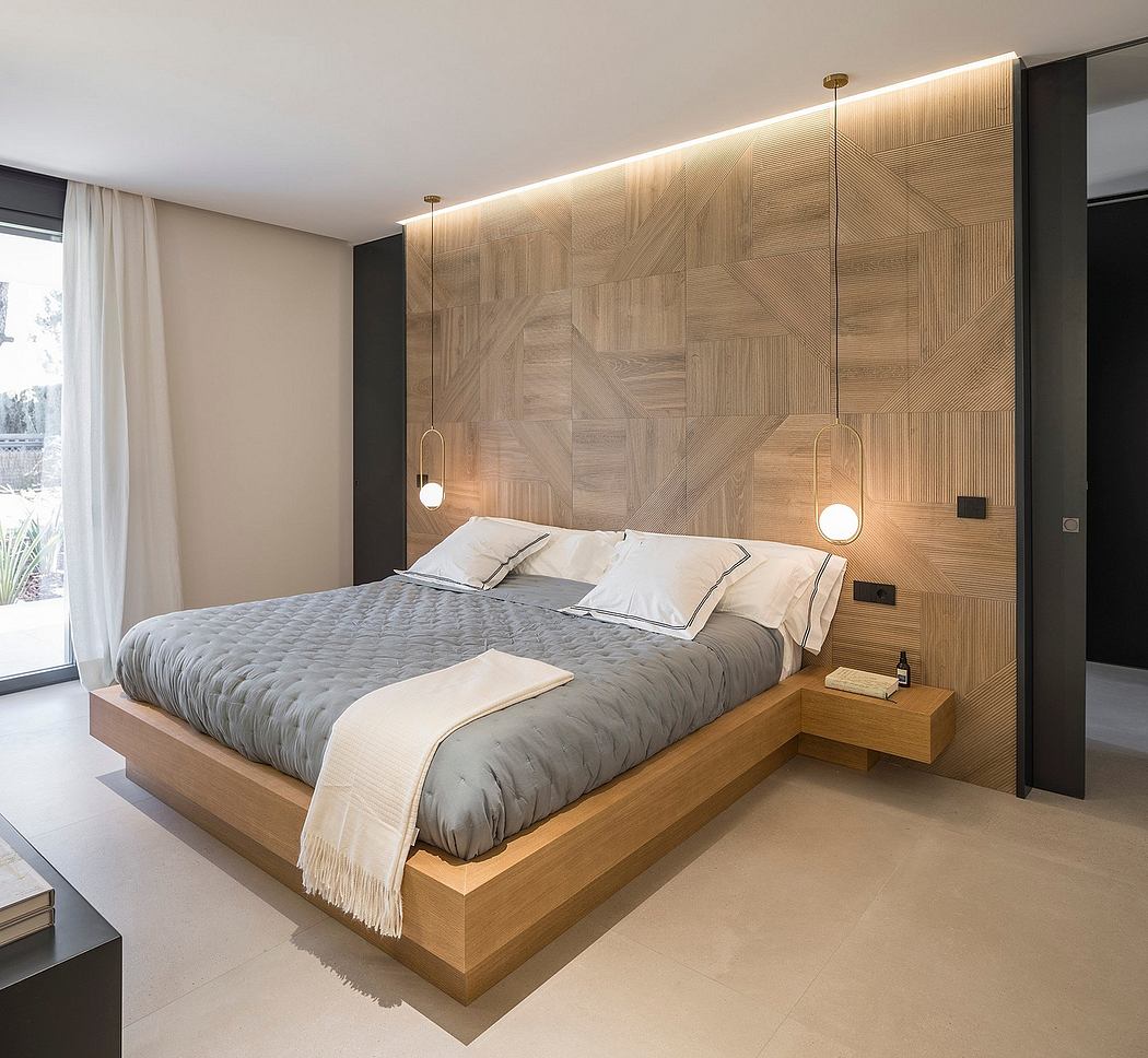 A modern and minimalist bedroom design featuring a wooden accent wall and pendant lighting.