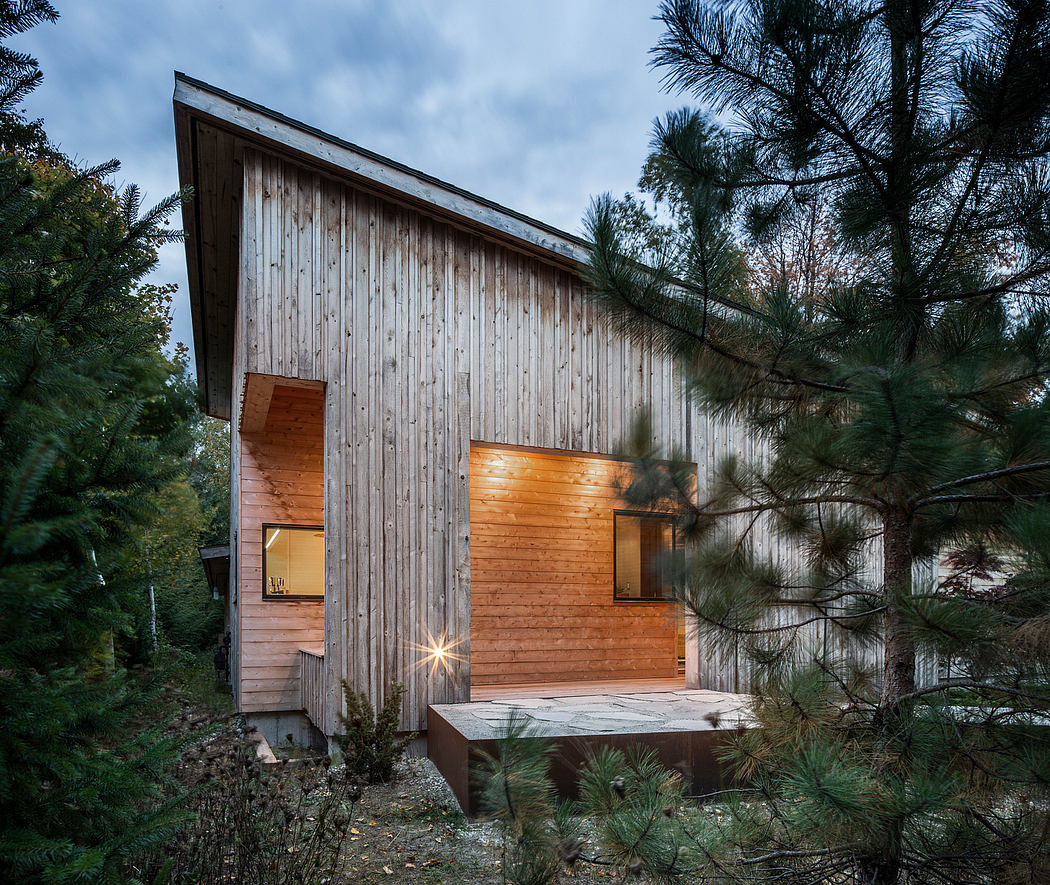 A rustic wooden cabin nestled in a lush, forested setting, featuring a cozy interior and a deck.