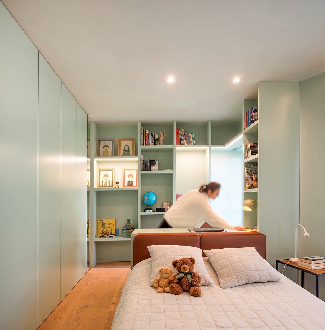 Cozy bedroom with built-in shelves, plush bedding, and framed artwork on walls.
