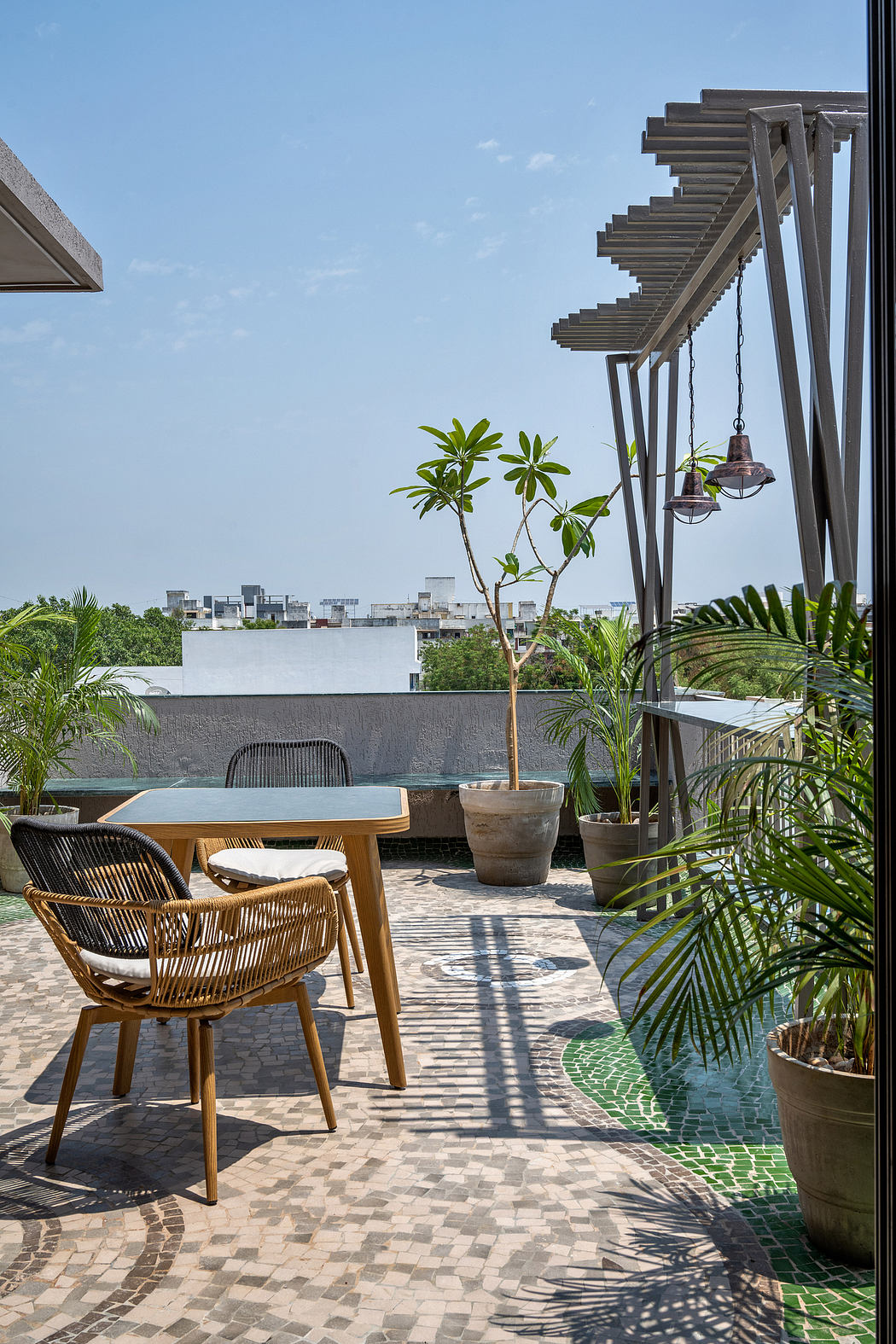 Modern outdoor terrace with wooden furniture, potted plants, and architectural details.