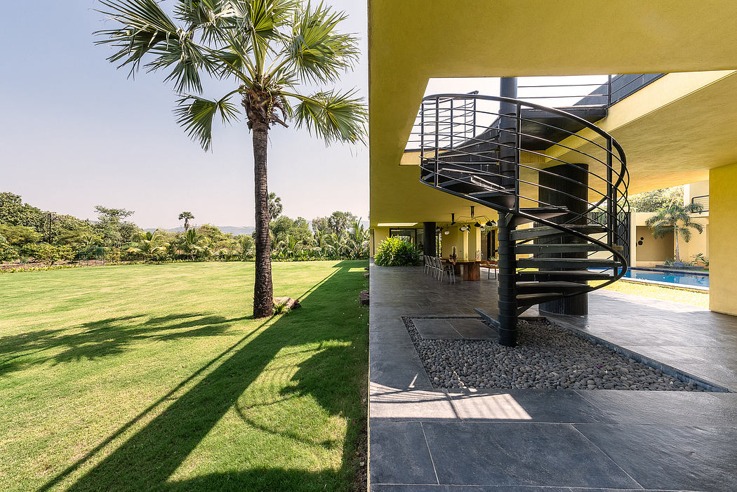 Striking modern architecture featuring spiral staircase, lush greenery, and pool.