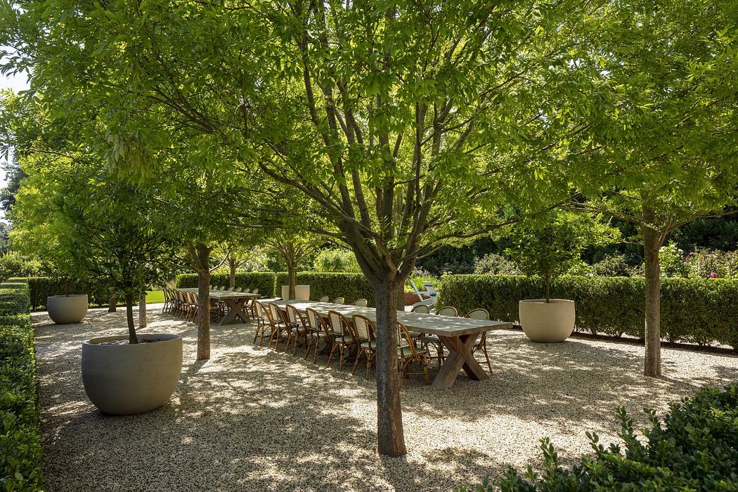 Serene outdoor dining area with lush greenery, wooden tables, and potted plants.