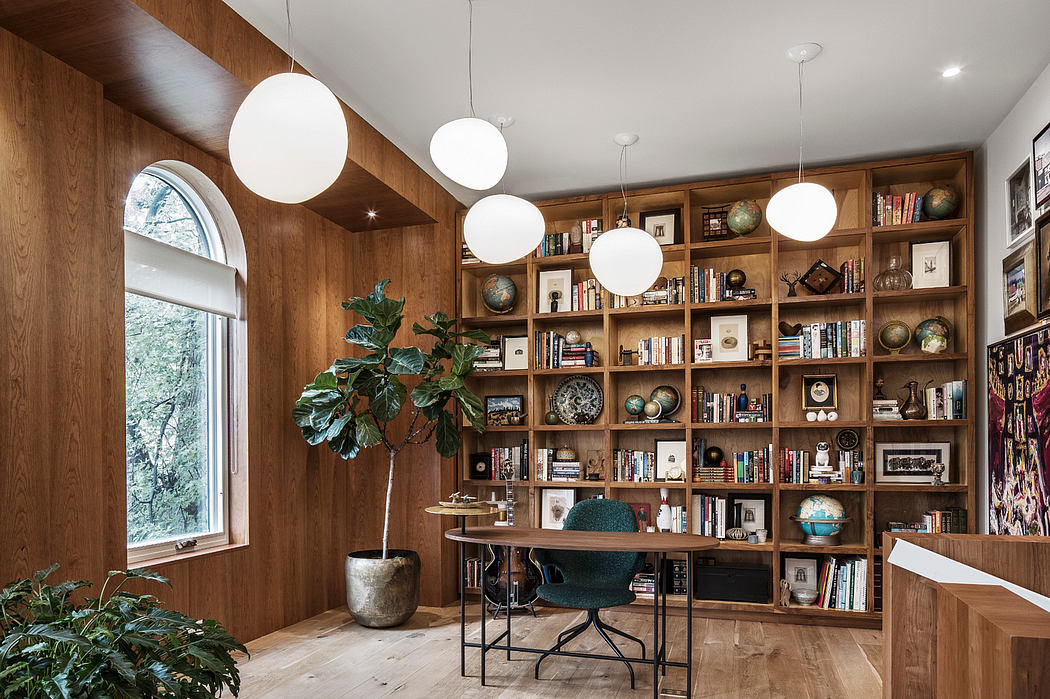 Cozy home office with built-in wooden bookshelves, globe decor, and pendant lighting.