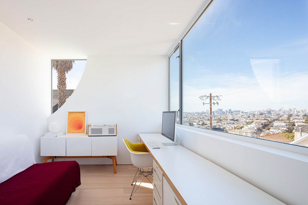Modern, minimal interior with large windows overlooking cityscape and palm tree.